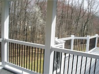 <b>View from inside a screened porch with white vinyl railing and black aluminum balusters</b>